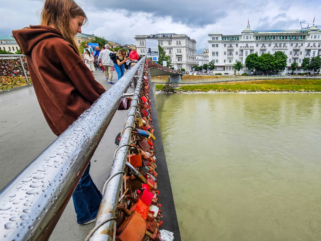 Girl looking at padlocks on a bridge