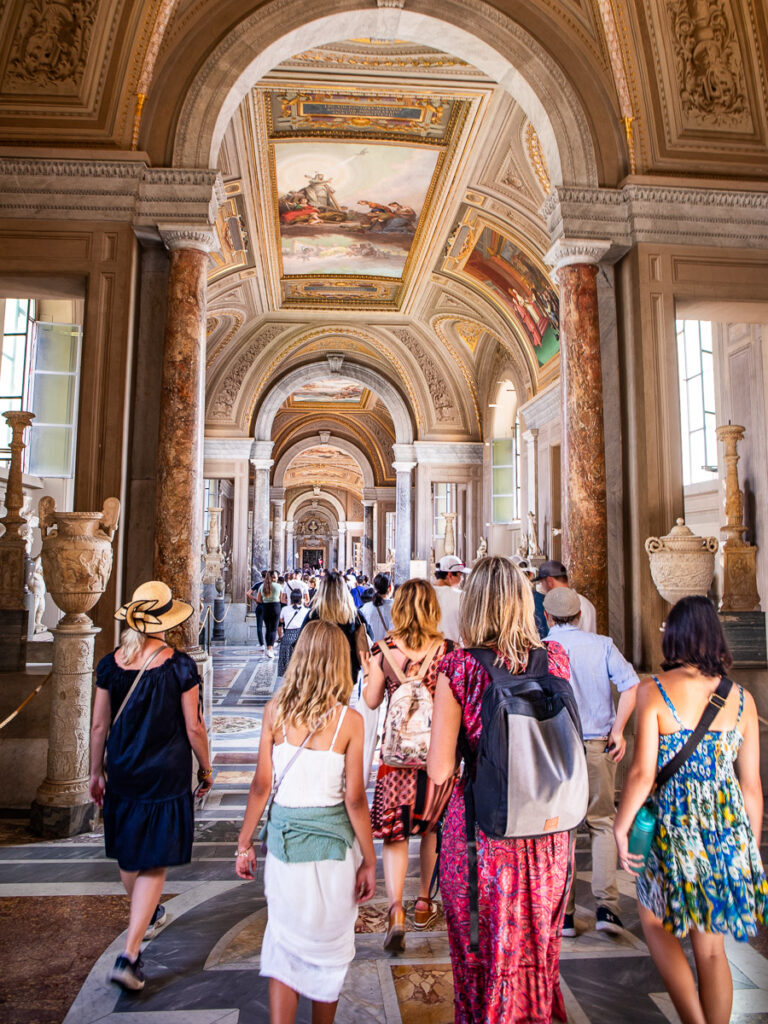 People walking through a hall in the Vatican in Rome