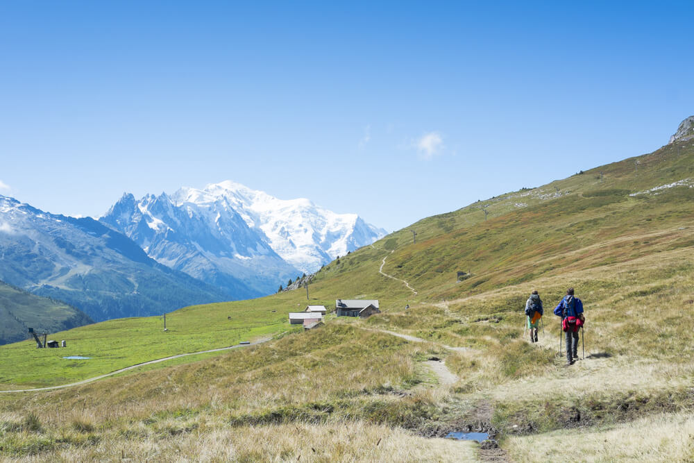 people on tour de mont blanc with snow peaked mountains in background