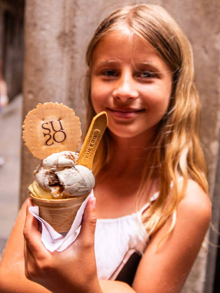 Young girl holding up and ice cream in Italy