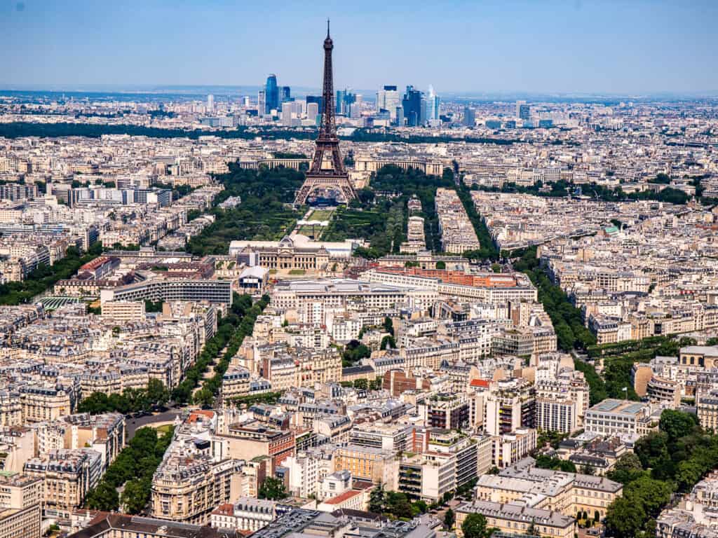 Aerial view tree lined streets in a city and a giant tower called the Eiffel Tower
