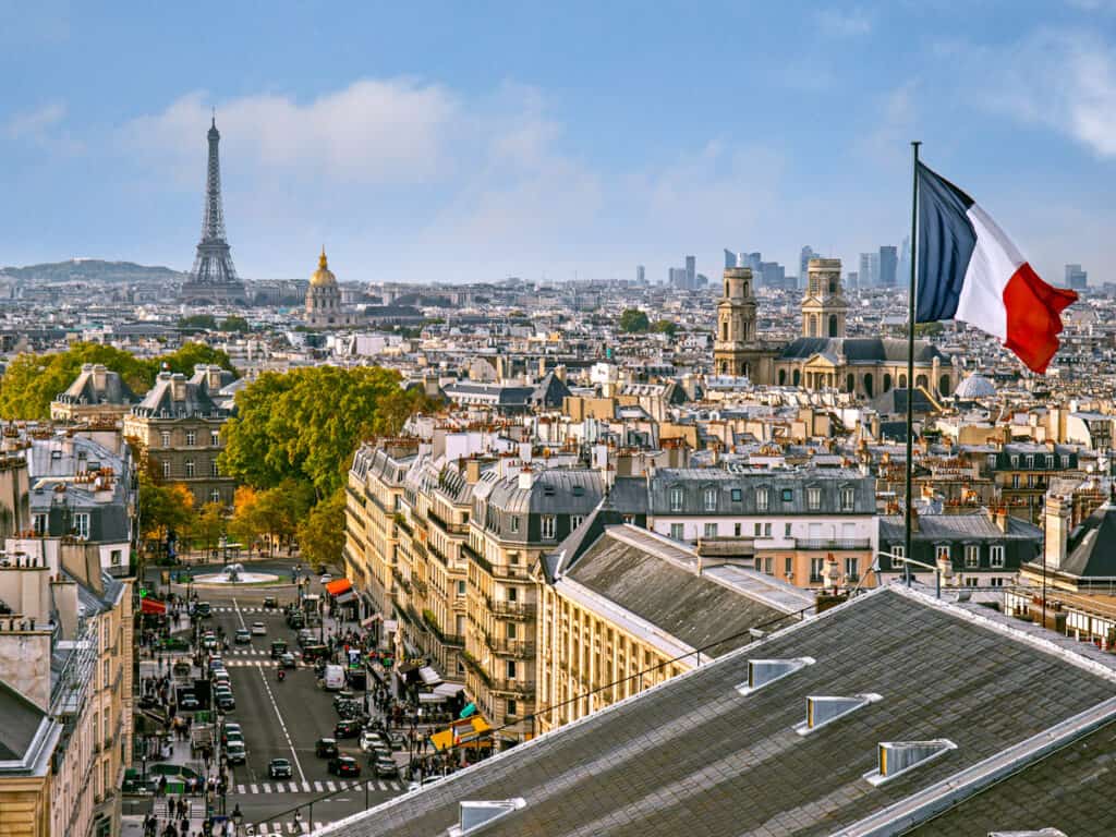 view of eiffel tower and french flag over city from pantheon.