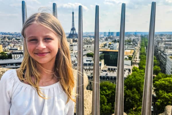savannah standing in front of guard rails with views of paris