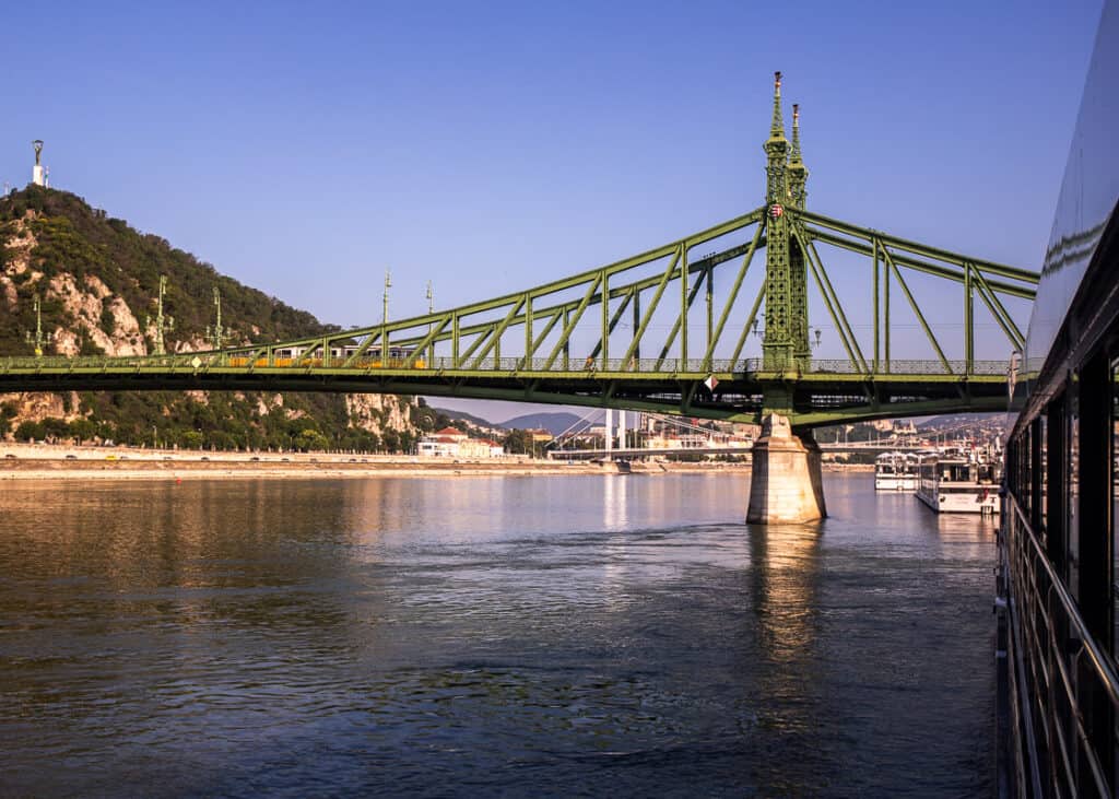 A green steel bridge spanning a river