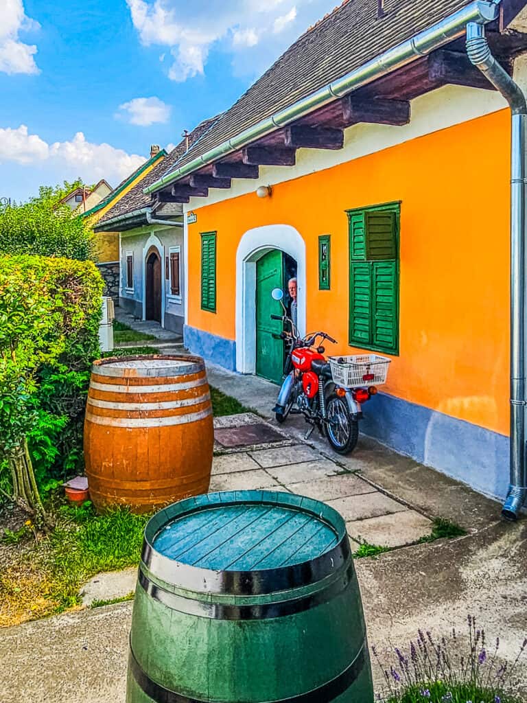 Wine barrels and a motor bike outside a colorful building