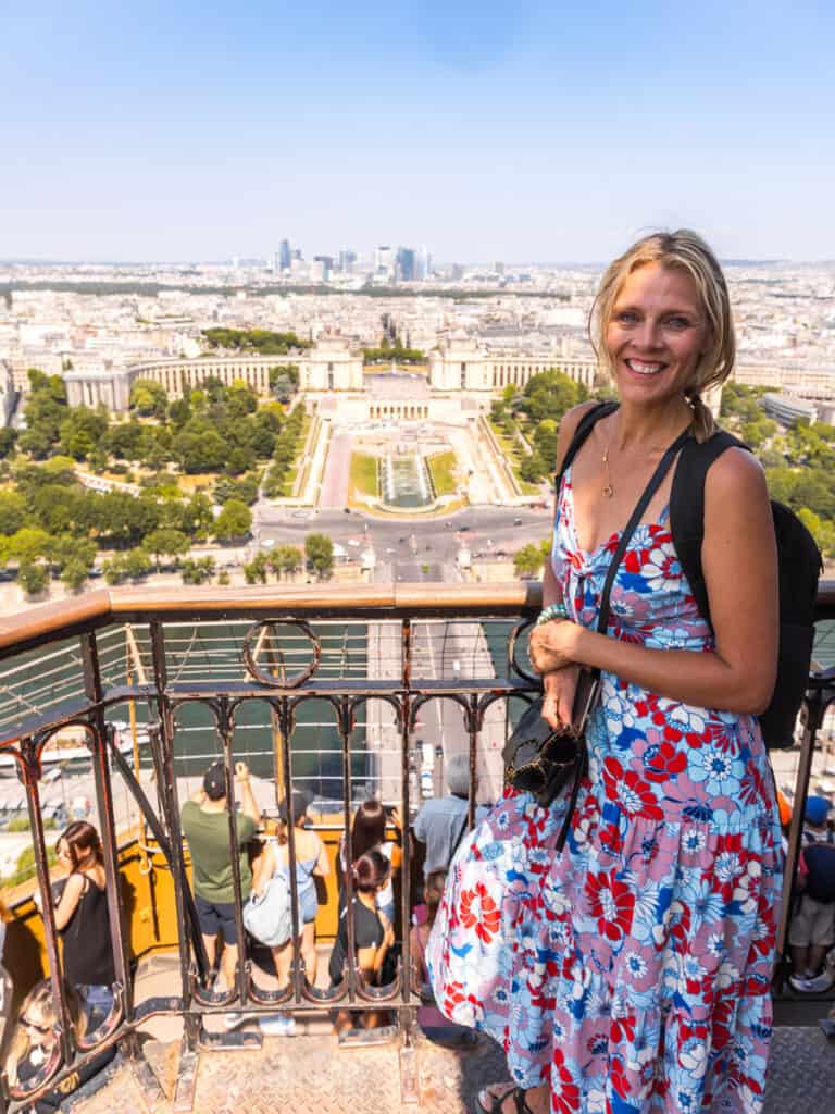 caz with view of paris behind her on eiffel tower