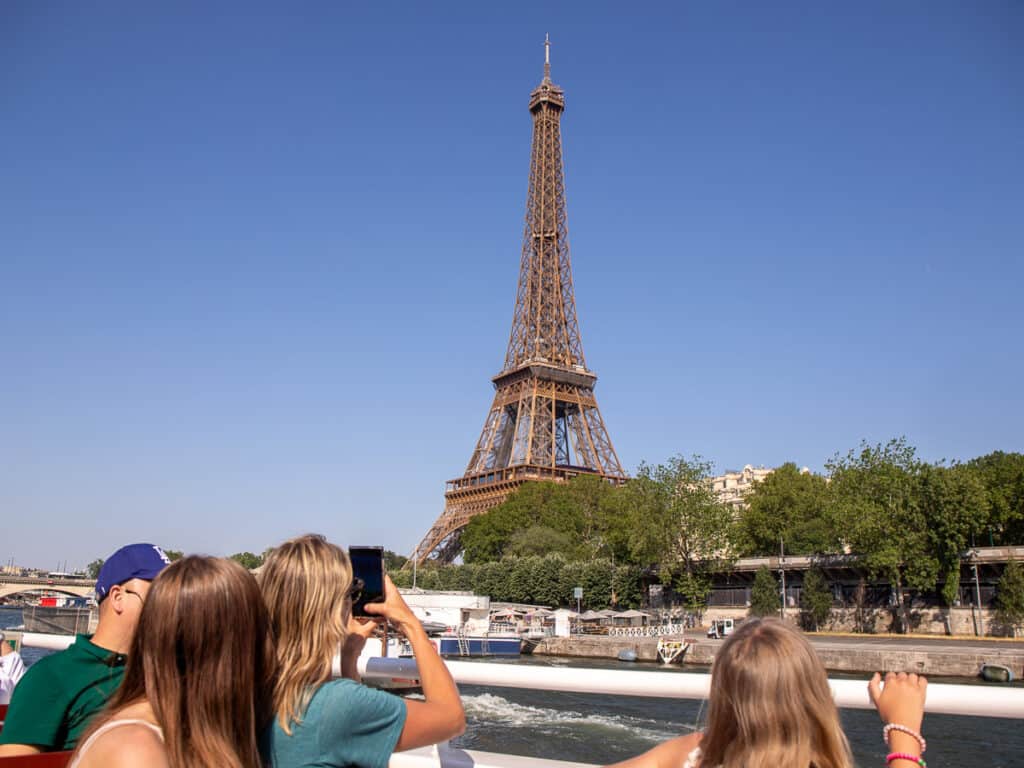 People looking up taking a photo of the Eiffel Tower in Paris
