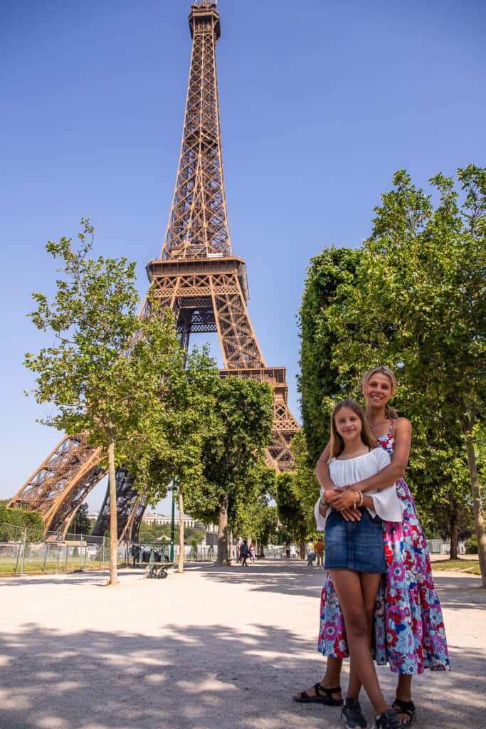 Mom and daughter hugging at the bottom of the Eiffel Tower