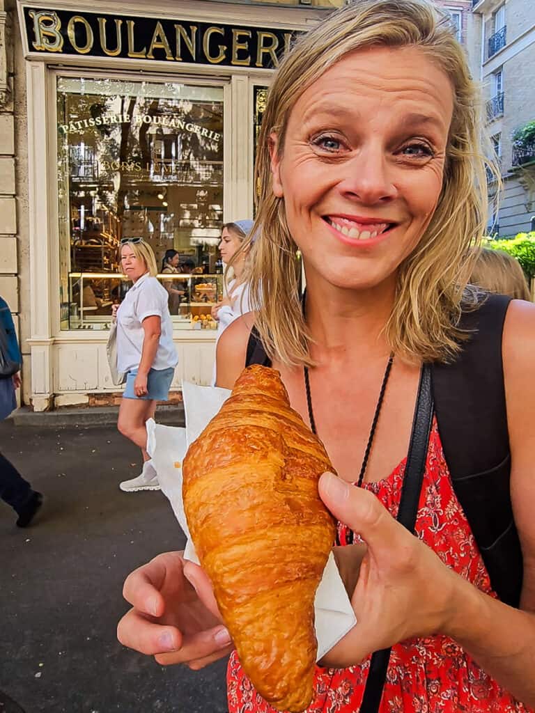 Lady holding a croissant in Paris