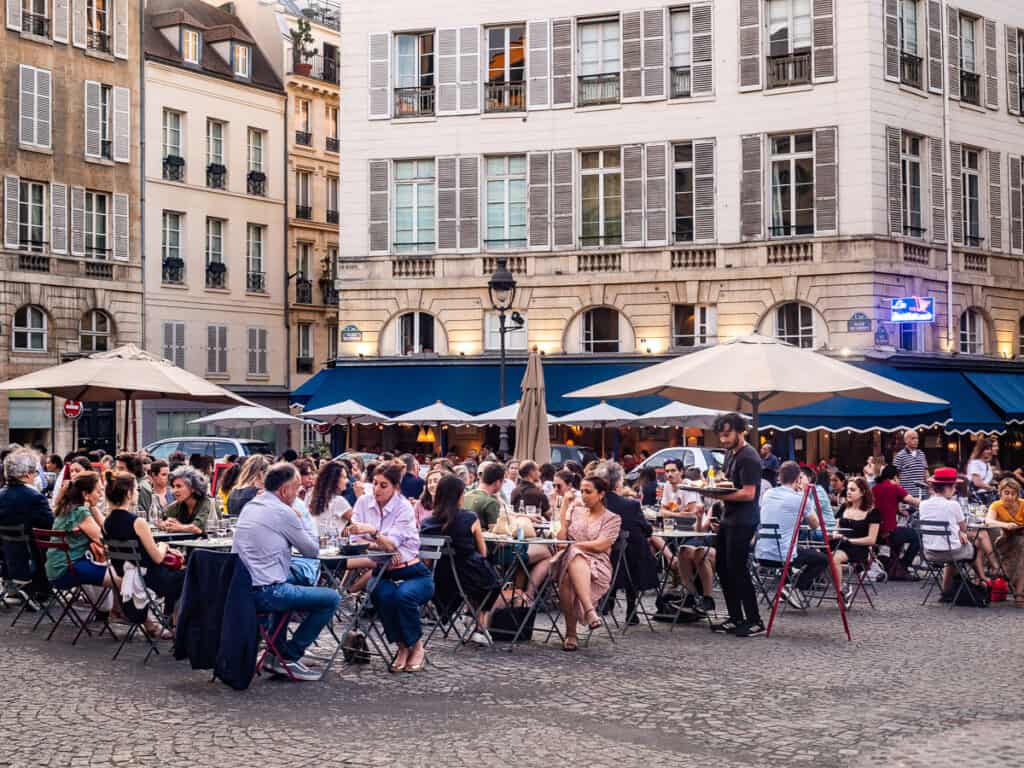 people sitting at cafes on square in paris