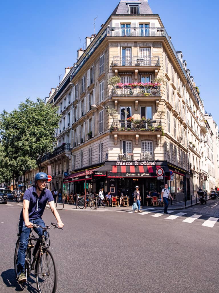 Man riding a bike through the city streets of Paris
