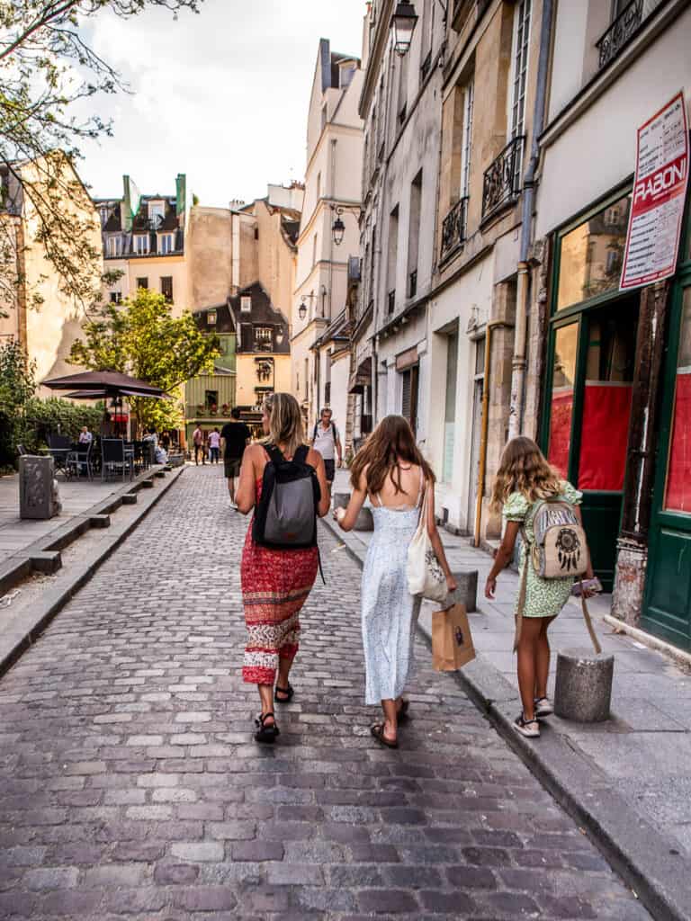 Mom and two daughters walking along a street in Paris