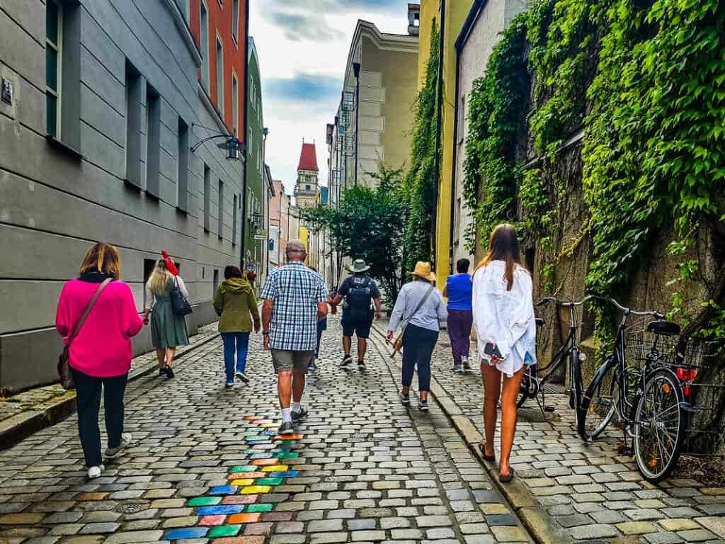 Group of people walking a cobblestone alleyway