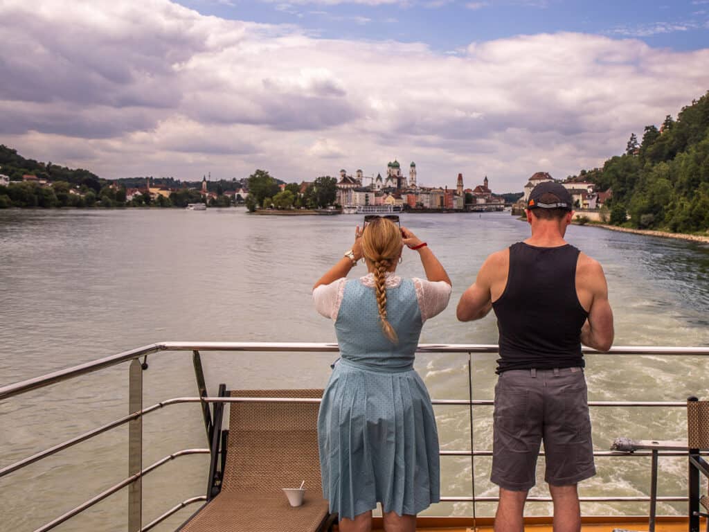 Man and a woman looking back over a river and city from a cruise ship