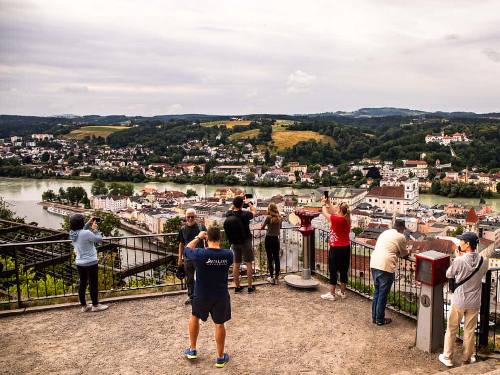Group of people taking photos overlooking a city below