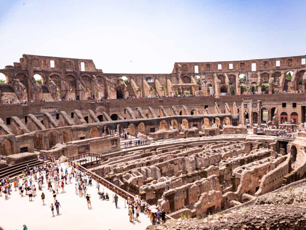 people standing on the arena floor in the colosseum