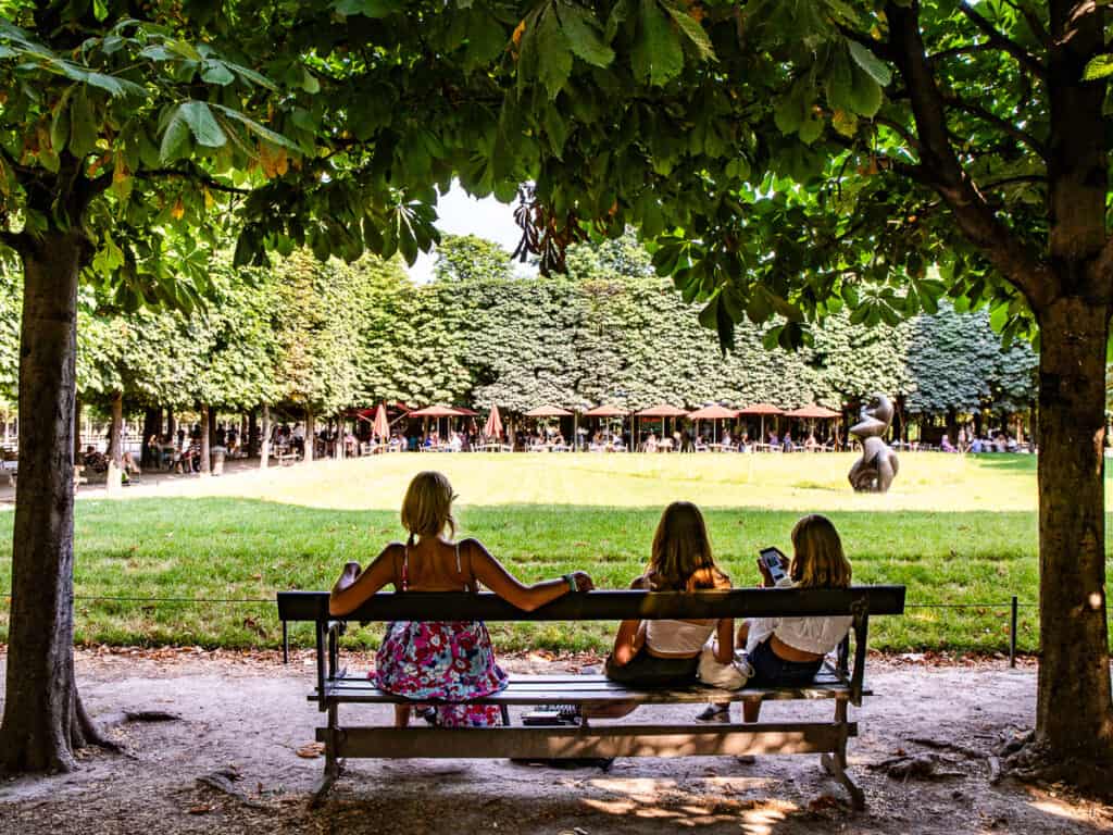 Mom and two daughters sitting in a park in Paris