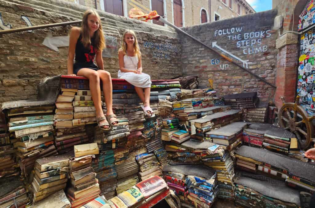 kalyra and savannah sitting on staircase of books