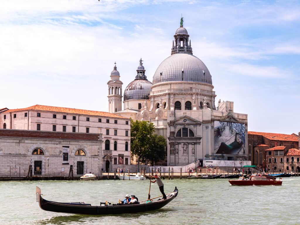 boat cruising in front of domed building on grand canal