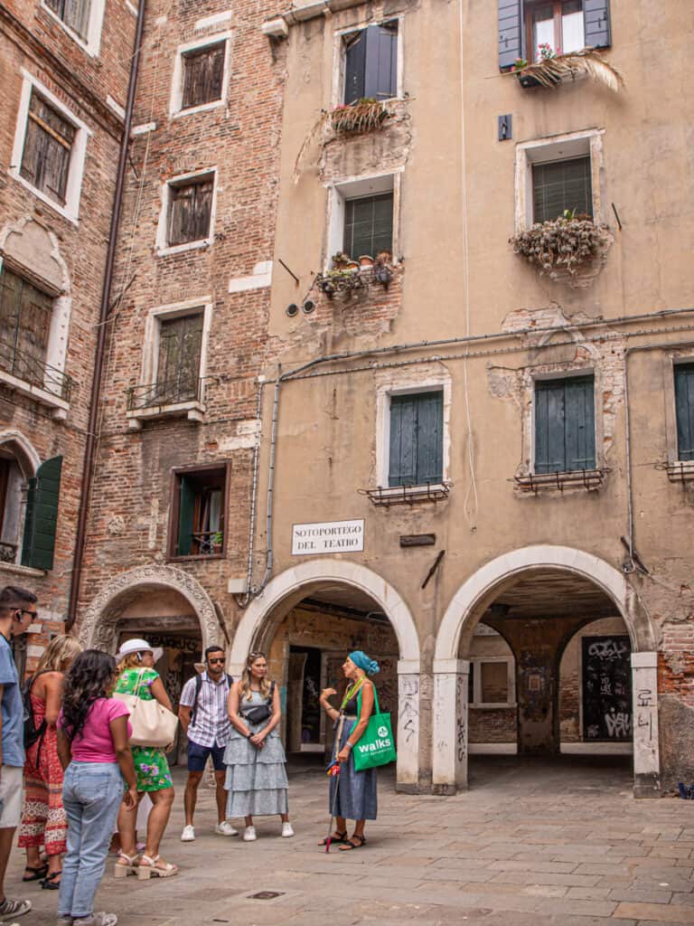 people standing in courtyard next to arched marco polo building