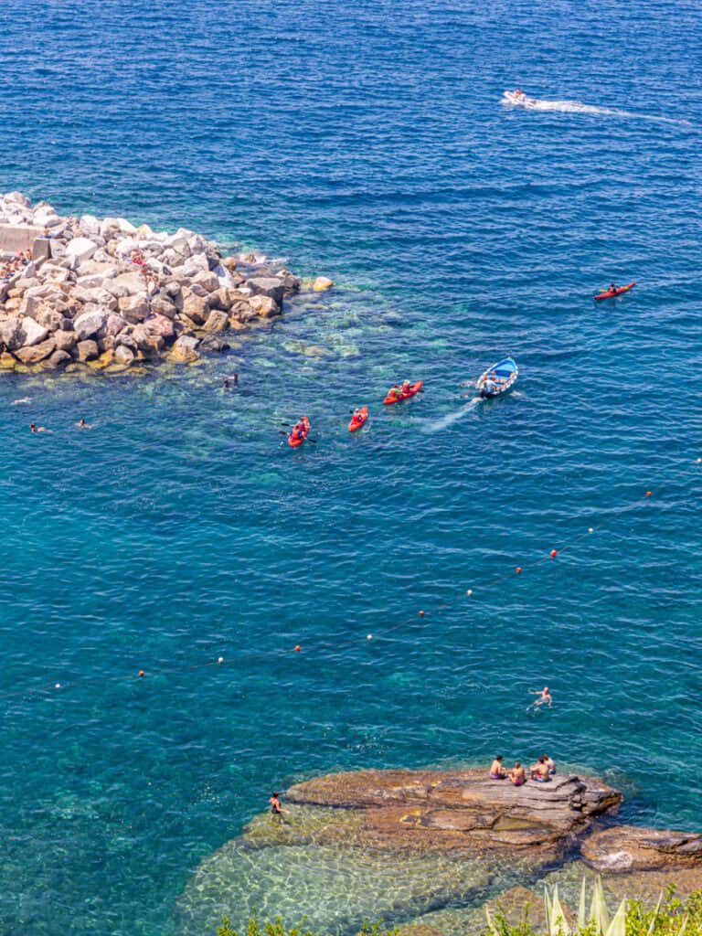 kayakers and swimmers in vernazza beach
