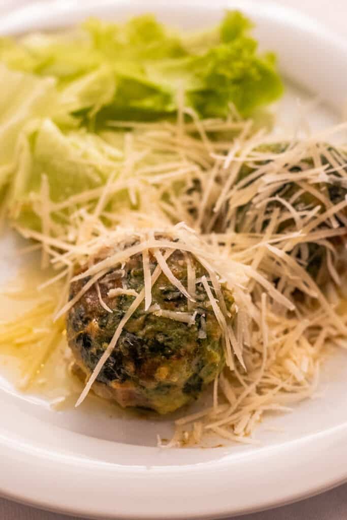 Spinach ball covered in shaved cheese