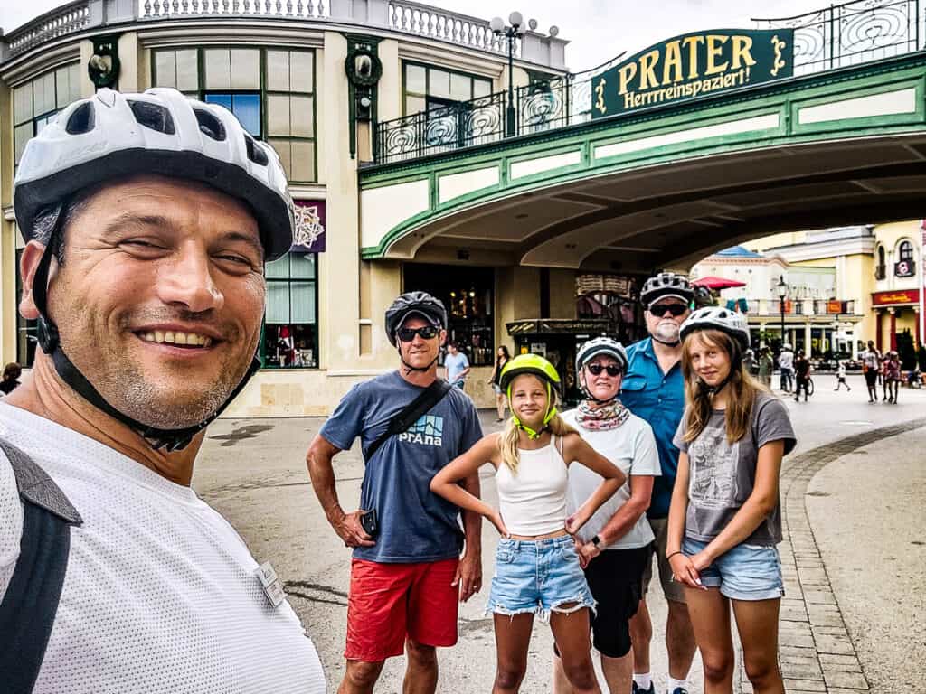 Group posing for a photo in front of a sign that says Prater