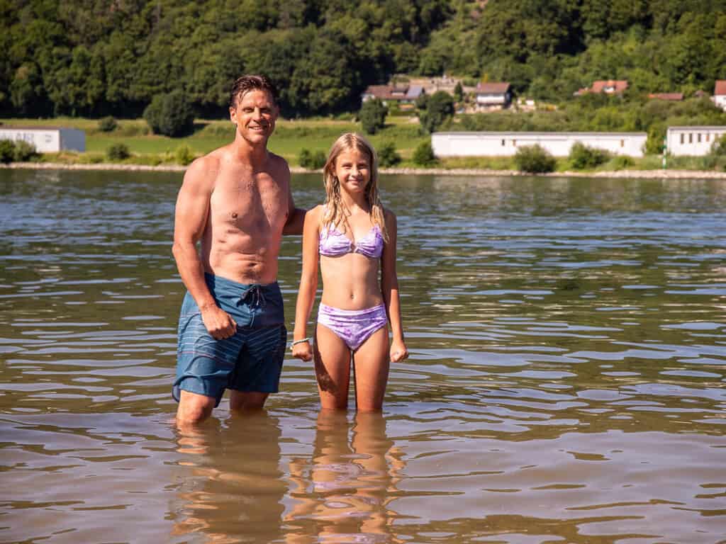 Dad and daughter standing in a river