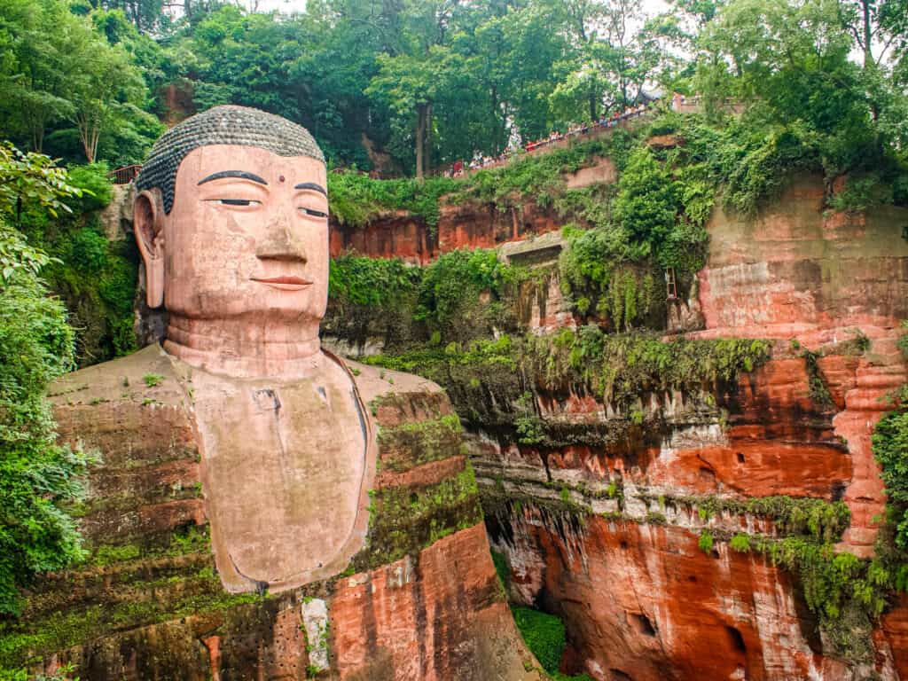 buddha carved into orange rock face