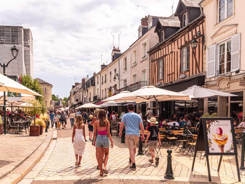 craig and girls walking past restaurants in Amboise