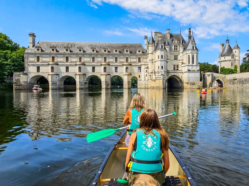 kalyra and caroline paddling a canoe in front of Château de Chenonceau 