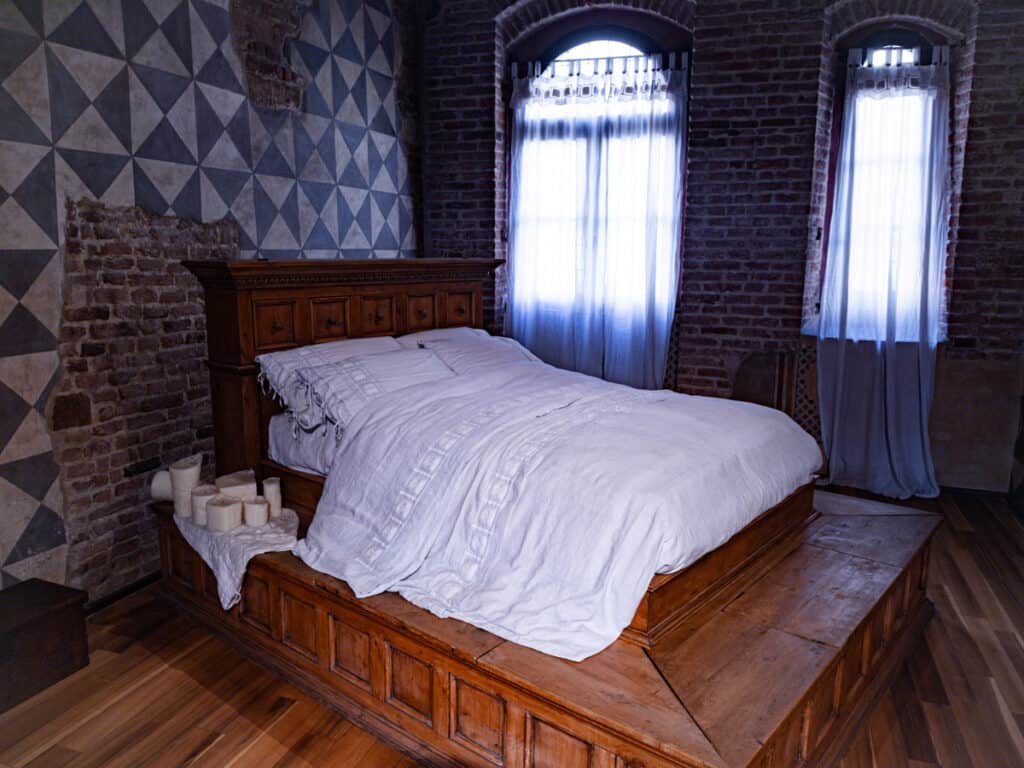 bed in middle of medieval room
