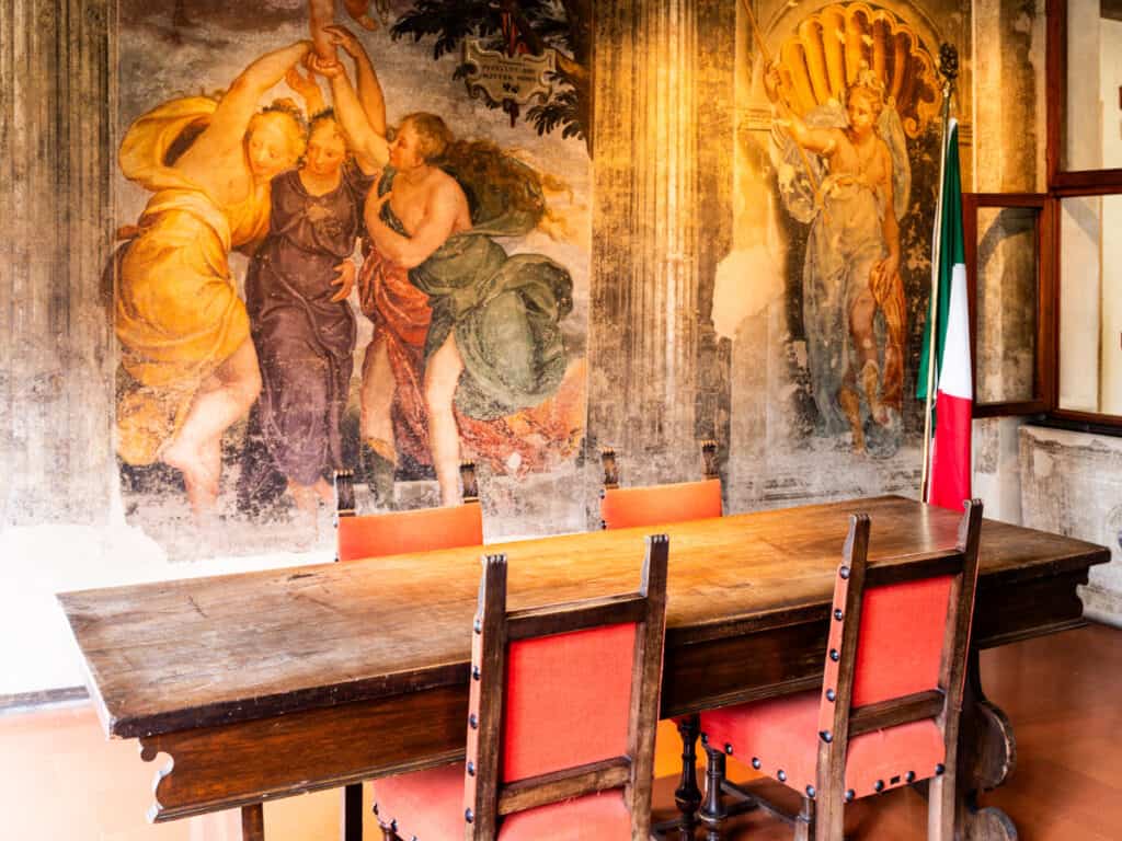 table in room with frescoes on wall