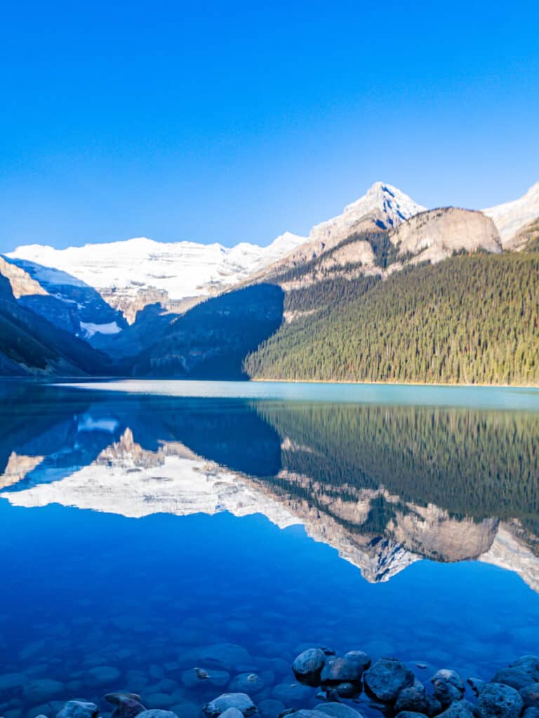reflections of snow capped mountains in lake louise