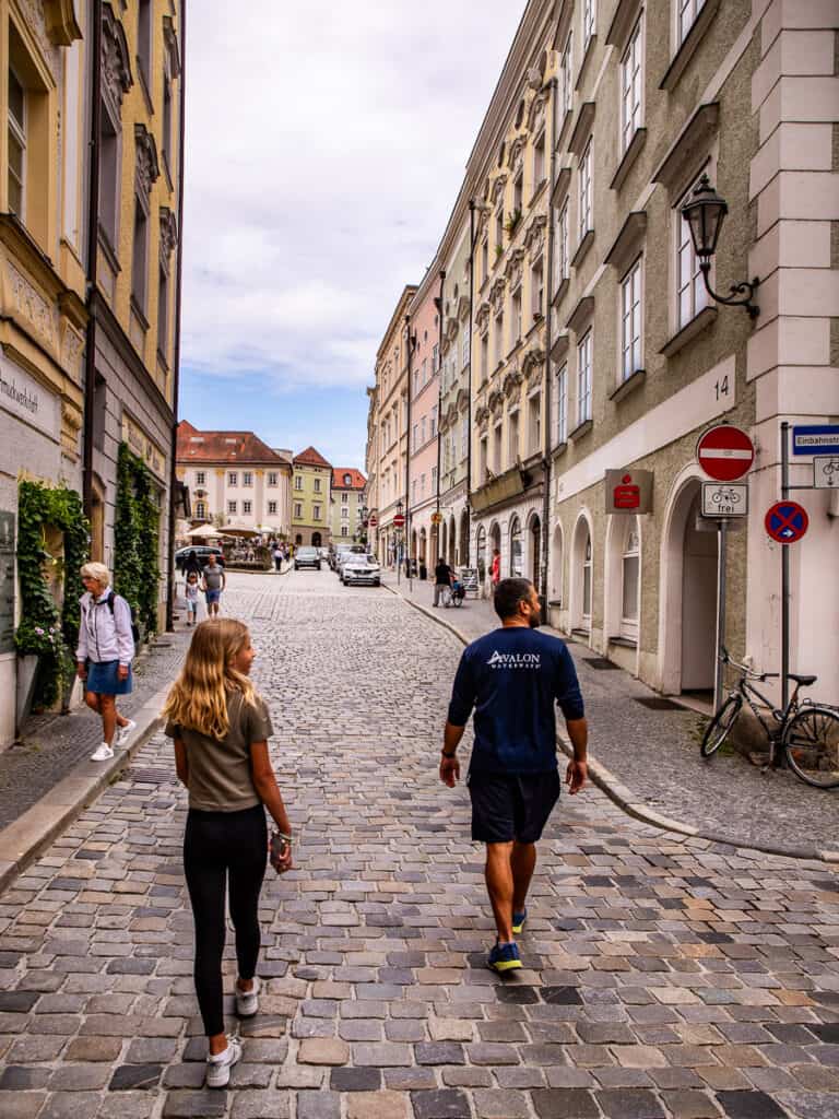 Young girl and man walking along a cobblestone street