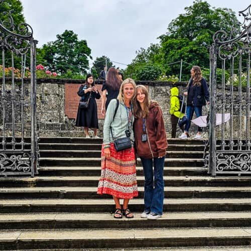 Mom and daughter standing on steps near a gate in Salzburg, Austria