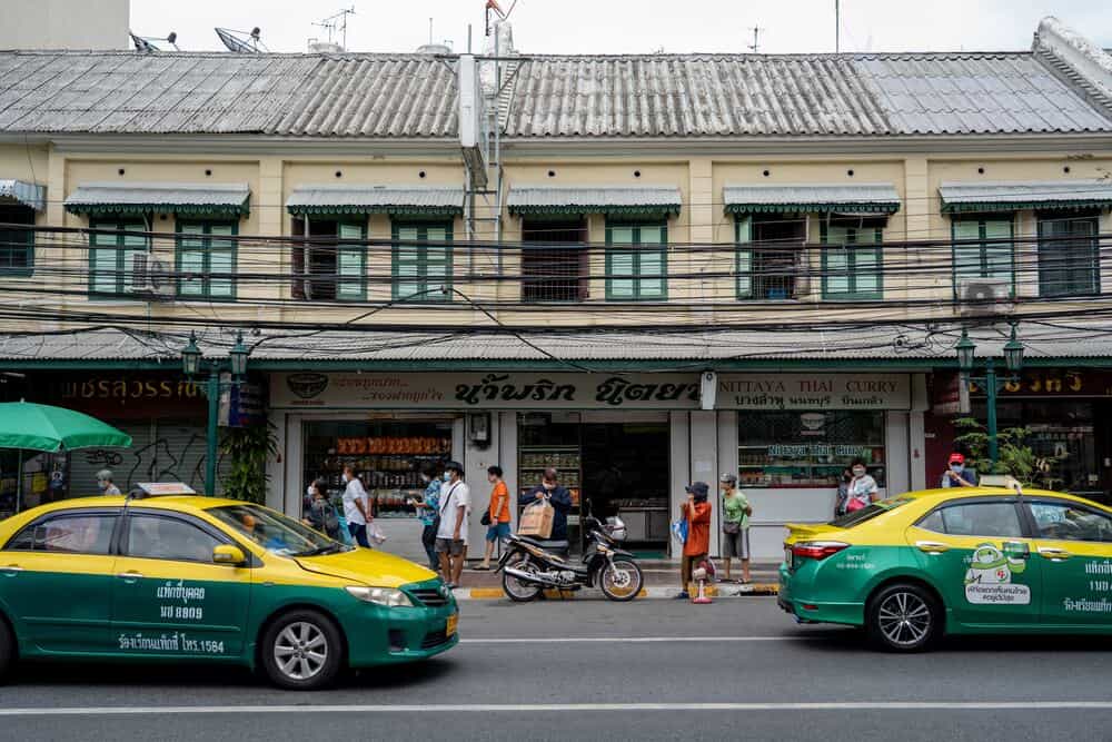 yellow and green taxis on bangkok road