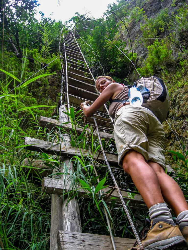 caroline climbing steep ladder out of gorge