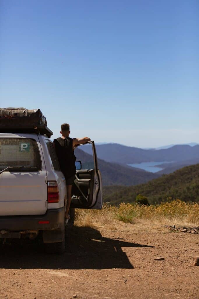 man standing out of car looking at views of lake eildon