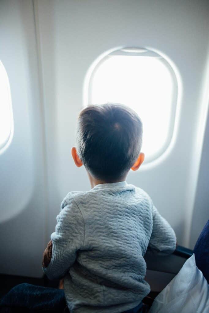 kid on the plane looking out window