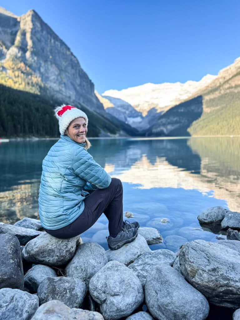 caz sitting on a rock in front of lake louise