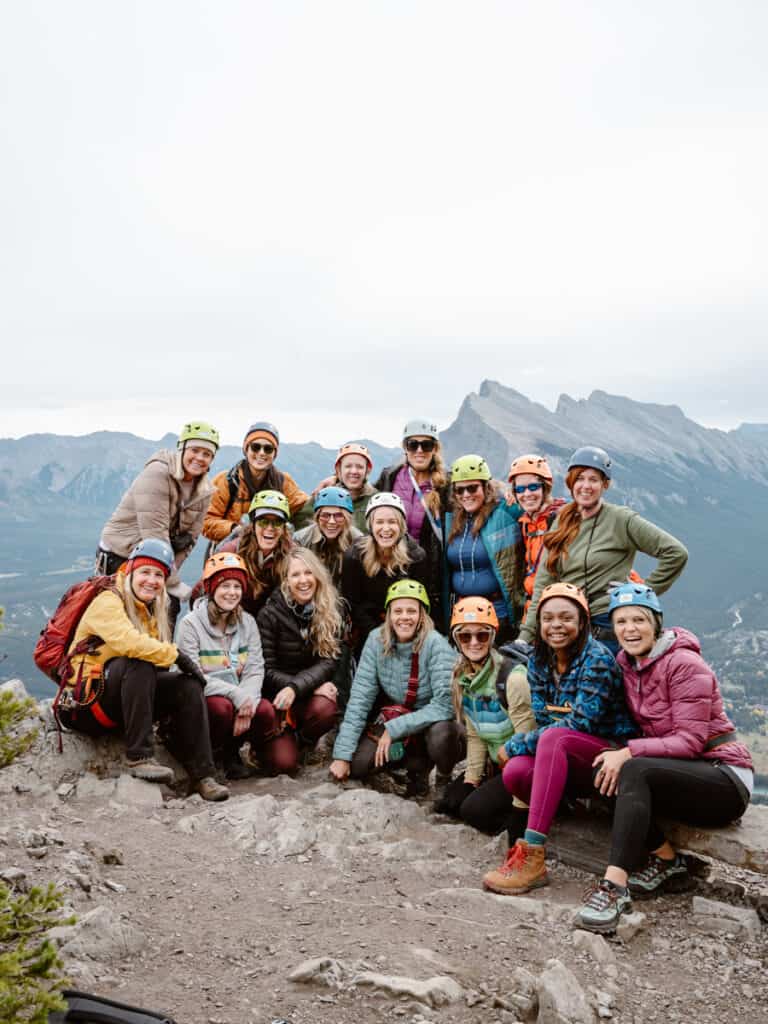 group of women on mountain ridge posing for photo