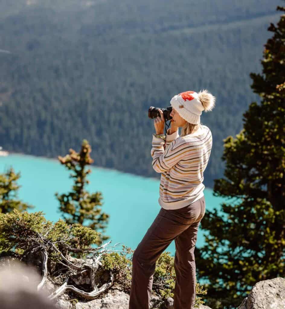 woman holding camera looking at lake louise