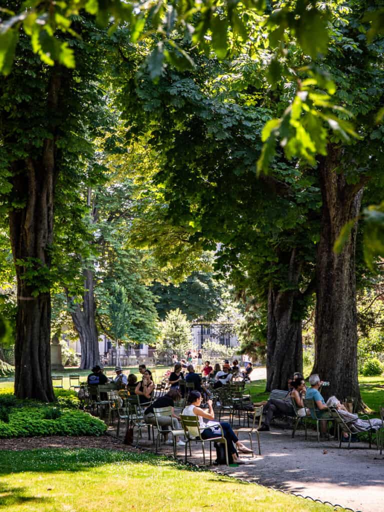 people sitting under shady trees in Luxembourg gardens