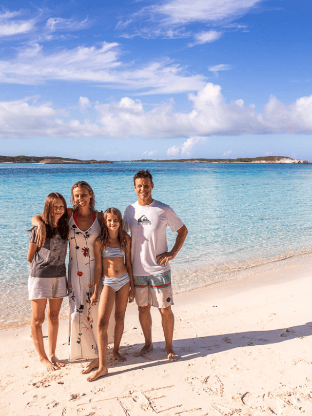 family standing on beautiful bahamas beach