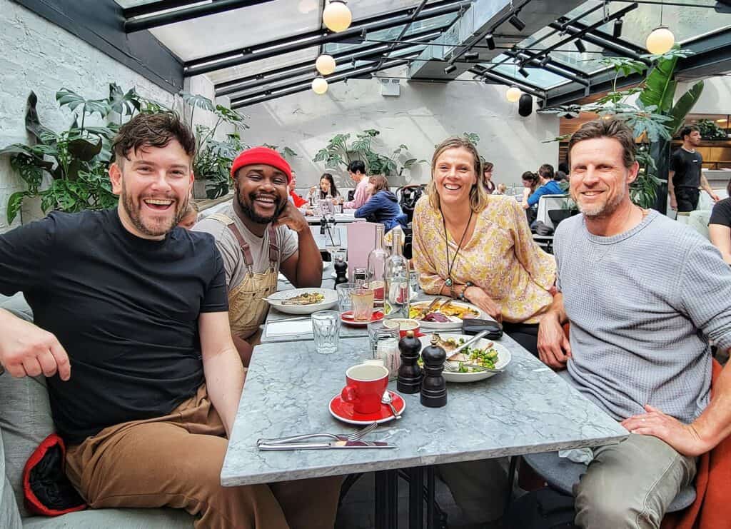 group of people sitting at table smiling at camera