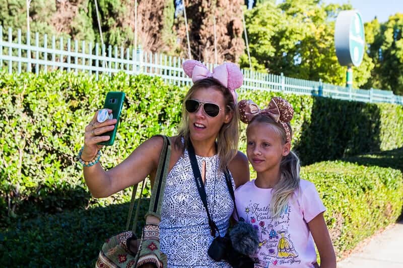 mother and daughter with mickey mouse ears on taking a selfie