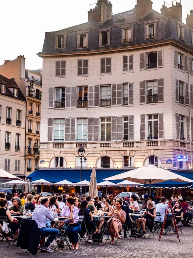 people sitting in restaurant in square in paris