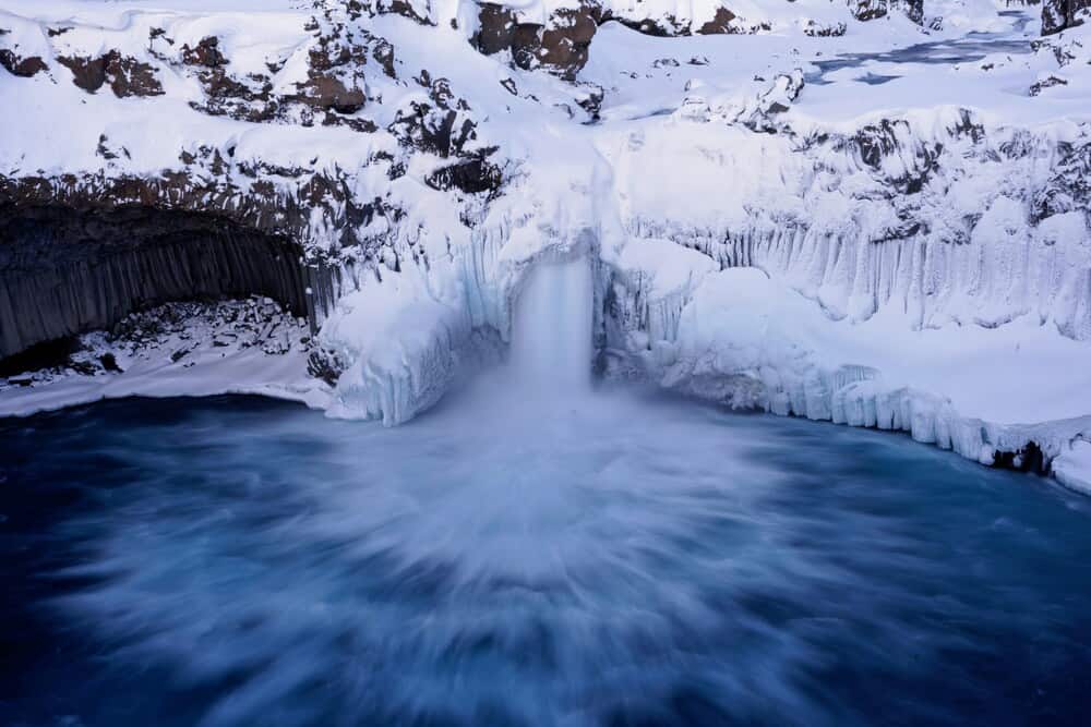 frozen waterfall and pool of water Aldeyjarfoss