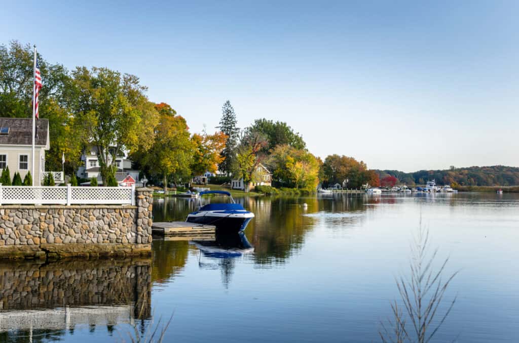 Waterside Houses with Boats Moored to Wooden Jetties on a Clera Autumn Day. Connecticut River, Essx, CT.
